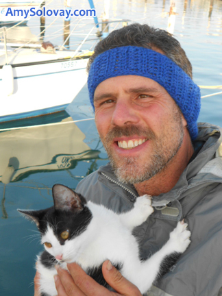 Mike Wearing a Crocheted Headband and Holding Cindy the SuperModel Kitten. A free crochet pattern is available online for the headband pattern.